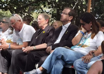 El presidente Isaac Herzog y Michal Herzog, segundo y tercero desde la derecha, junto a Yael Adar, madre de Tamir Adar, en su funeral en el kibutz Nir Oz el 23 de octubre de 2025. (Cortesía de Hostages Forum)