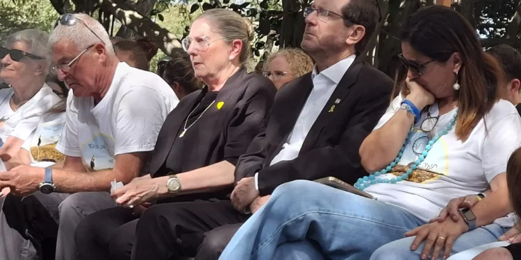 El presidente Isaac Herzog y Michal Herzog, segundo y tercero desde la derecha, junto a Yael Adar, madre de Tamir Adar, en su funeral en el kibutz Nir Oz el 23 de octubre de 2025. (Cortesía de Hostages Forum)