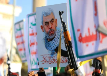 Yemeníes blanden rifles y sostienen una foto del líder terrorista de Hamás, Yahya Sinwar, asesinado, durante una manifestación en solidaridad con Gaza en Saná, la capital controlada por los hutíes, el 29 de noviembre de 2024. (Mohammed HUWAIS / AFP)