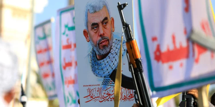 Yemeníes blanden rifles y sostienen una foto del líder terrorista de Hamás, Yahya Sinwar, asesinado, durante una manifestación en solidaridad con Gaza en Saná, la capital controlada por los hutíes, el 29 de noviembre de 2024. (Mohammed HUWAIS / AFP)
