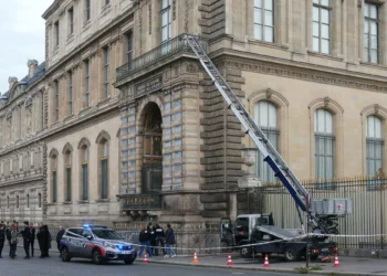 Agentes de la policía francesa junto a un elevador de cesta utilizado por los ladrones para entrar en el Museo del Louvre, en el Quai Francois Mitterrand, en París, el 19 de octubre de 2025. (Dimitar DILKOFF / AFP)