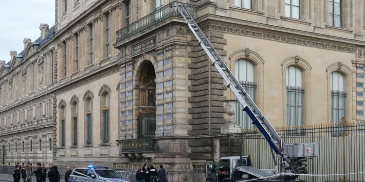 Agentes de la policía francesa junto a un elevador de cesta utilizado por los ladrones para entrar en el Museo del Louvre, en el Quai Francois Mitterrand, en París, el 19 de octubre de 2025. (Dimitar DILKOFF / AFP)