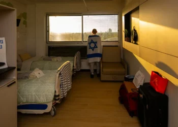 El exrehén Rom Braslavski mira el horizonte de Tel Aviv desde su habitación en el hospital Tel Hashomer después de su liberación del cautiverio el 13 de octubre de 2025. (GPO)