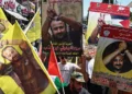 Manifestantes levantan banderas y carteles que representan a Marwan Barghouti, destacado miembro del partido Fatah y el terrorista palestino de más alto perfil encarcelado por Israel, durante una marcha en su apoyo en la ciudad de Ramallah, el 19 de agosto de 2025. (Zain JAAFAR / AFP)