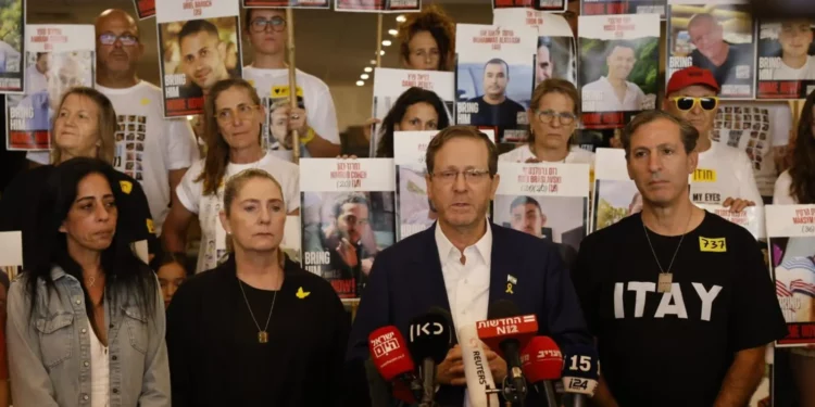 Isaac Herzog, segundo a la derecha, con familiares de rehenes dirigiéndose a una multitud en Tel Aviv el 12 de octubre de 2025. (Yossi Zamir/GPO)