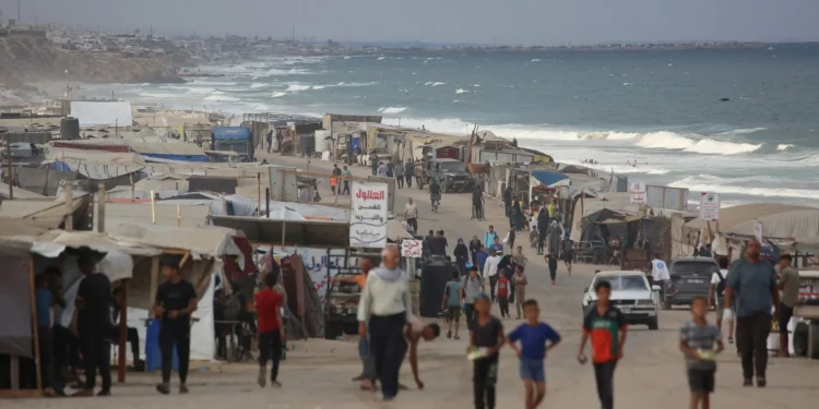 Palestinos desplazados comienzan su día en un campamento improvisado junto a la playa en la ciudad de Al-Zawayda, cerca de Deir al-Balah, en el centro de la Franja de Gaza, el 9 de octubre de 2025, tras el anuncio nocturno de un acuerdo de alto el fuego entre Hamás e Israel, que se firmará en Egipto. (Bashar TALEB / AFP)