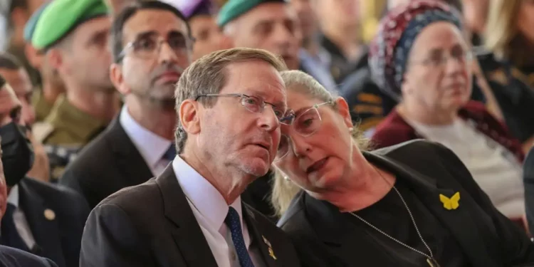 El presidente Isaac Herzog, a la izquierda, y su esposa Michal asisten a una ceremonia de estado en conmemoración del aniversario del ataque terrorista de Hamás del 7 de octubre, en el cementerio militar del Monte Herzl en Jerusalén, el 16 de octubre de 2025. (Alex Kolomoisky/POOL)