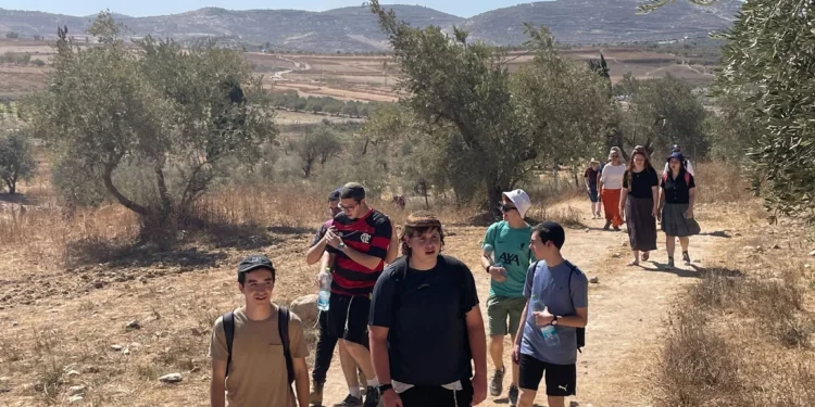 La gente marcha en el norte de Judea y Samaria, celebrando los 50 años de asentamientos en la región de Samaria, el 8 de octubre de 2025. (Jeremy Sharon/Times of Israel)