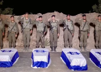 Tropas de las Fuerzas de Defensa de Israel saludan ante los ataúdes que contienen los cuerpos de los rehenes asesinados Guy Illouz, Bipin Joshi, Yossi Sharabi y Daniel Pérez en la Franja de Gaza, a finales del 13 de octubre de 2025. (Fuerzas de Defensa de Israel)