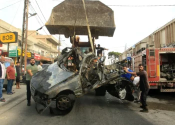 Una excavadora retira los restos de un vehículo objetivo de un ataque con dron israelí en la aldea de Doueir, en el sur del Líbano, cerca de la ciudad de Nabatiyeh, el 3 de noviembre de 2025. (Mahmoud ZAYYAT / AFP)