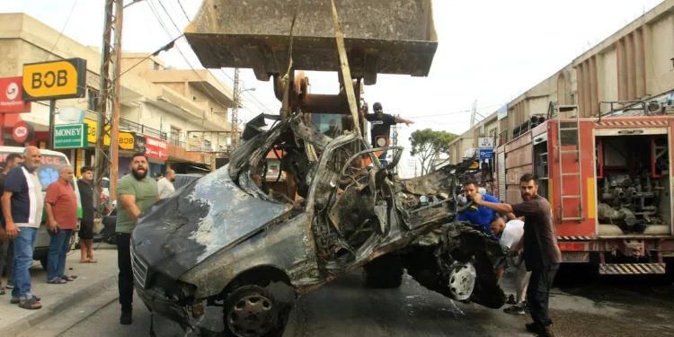 Una excavadora retira los restos de un vehículo objetivo de un ataque con dron israelí en la aldea de Doueir, en el sur del Líbano, cerca de la ciudad de Nabatiyeh, el 3 de noviembre de 2025. (Mahmoud ZAYYAT / AFP)