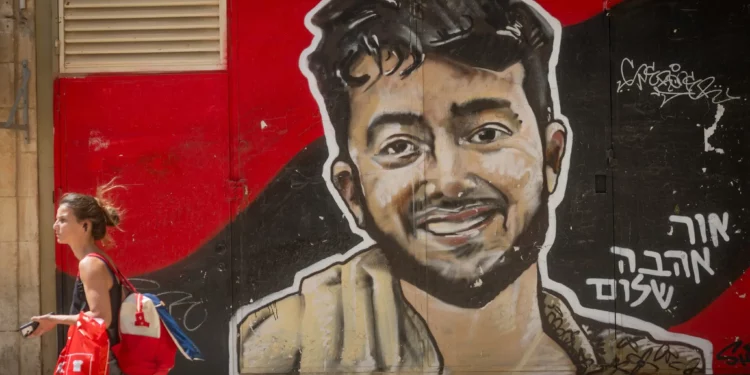 Personas caminan junto a un mural del rehén asesinado Hersh Goldberg-Polin en el centro de Jerusalén, 18 de agosto de 2025. (Foto de Chaim Goldberg/Flash90)