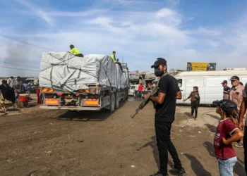 Un hombre armado vigila la entrada de ayuda humanitaria a Gaza a través del cruce fronterizo israelí de Kerem Shalom, en Jan Yunis, en el sur de la Franja de Gaza, el 2 de noviembre de 2025. (Abed Rahim Khatib/Flash90)