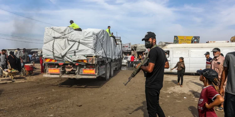 Un hombre armado vigila la entrada de ayuda humanitaria a Gaza a través del cruce fronterizo israelí de Kerem Shalom, en Jan Yunis, en el sur de la Franja de Gaza, el 2 de noviembre de 2025. (Abed Rahim Khatib/Flash90)