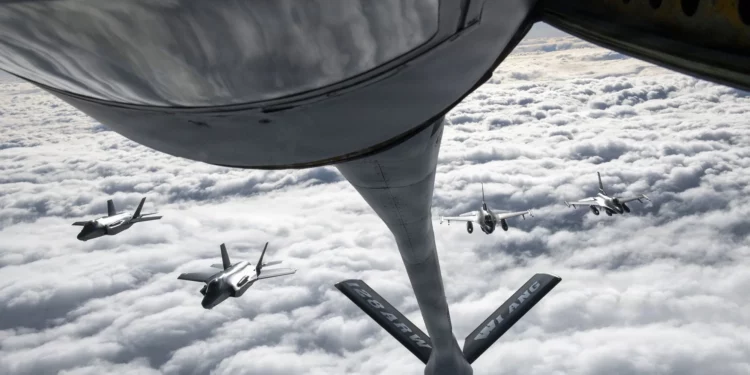 Una pluma de reabastecimiento de combustible del KC-135 Stratotanker sobre los dos F-35A y F-16.