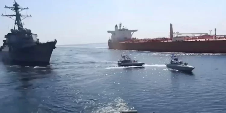 Una captura de pantalla de un video difundido por la Guardia Revolucionaria iraní el 3 de noviembre de 2021 muestra lanchas rápidas de la Guardia, en el centro, frente a un buque de guerra estadounidense, a la izquierda, durante la incautación de un petrolero con bandera vietnamita, a la derecha, en el Golfo de Omán. (Guardia Revolucionaria vía AP)