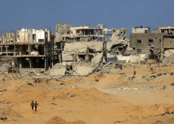 Palestinos caminan entre edificios destruidos en la zona oriental de Khan Younis, en el sur de la Franja de Gaza, el 12 de noviembre de 2025. (Abed Rahim Khatib/Flash90)