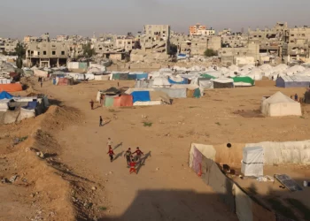 Niños juegan cerca de refugios y tiendas de campaña en el campamento de Bureij, en el centro de la Franja de Gaza, el 18 de noviembre de 2025. (Eyad Baba / AFP)