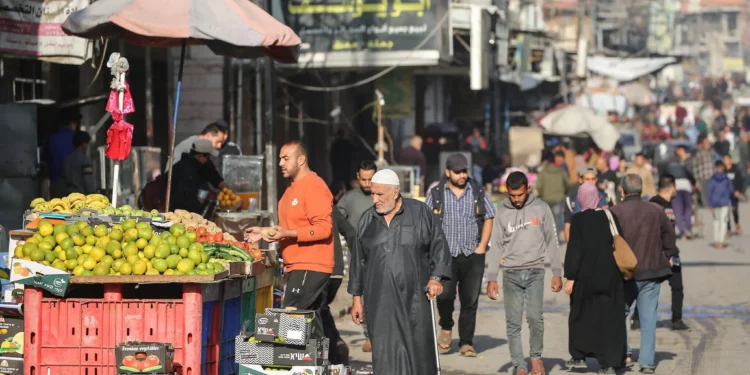 Palestinos caminan por una calle de mercado en Deir al-Balah, en el centro de la Franja de Gaza, el 20 de noviembre de 2025. (Eyad Baba / AFP)