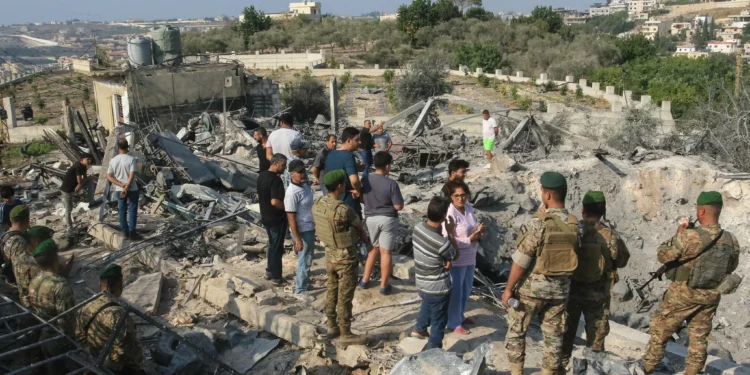 Soldados libaneses y residentes locales se encuentran en el lugar de un ataque aéreo israelí en la aldea de Toura, al sur del Líbano, el 6 de noviembre de 2025. (Mahmoud Zayyat / AFP)