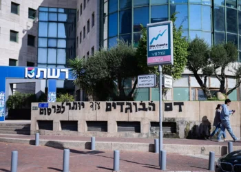 Vista de grafitis pintados durante la noche frente a las oficinas del Canal 13 en Tel Aviv, 19 de noviembre de 2025 (Avshalom Sassoni/Flash90)