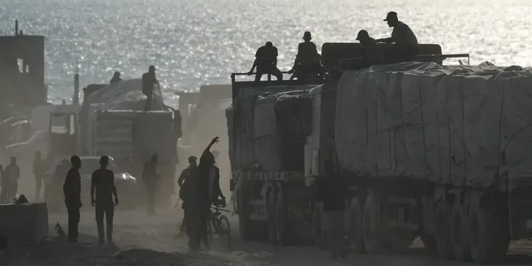 Camiones que transportan mercancías comerciales circulan por la ciudad de Gaza tras entrar desde Israel por el paso fronterizo de Zikim, en el norte de la Franja de Gaza, el 13 de noviembre de 2025. (AP/Jehad Alshrafi)