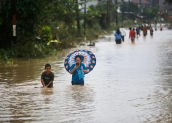 La gente camina a través del agua en una calle inundada en Medan, Sumatra del Norte, Indonesia, el 27 de noviembre de 2025. (Foto AP/Binsar Bakkara)