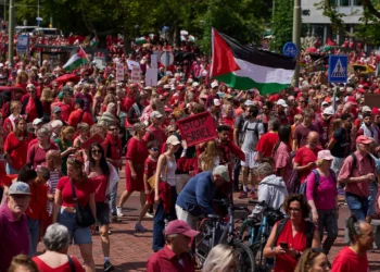 Decenas de miles de manifestantes vestidos de rojo marchan exigiendo que su gobierno haga más para detener la campaña de Israel en Gaza contra Hamás, durante una manifestación en La Haya, Países Bajos, el 15 de junio de 2025. (Foto AP/Peter Dejong)