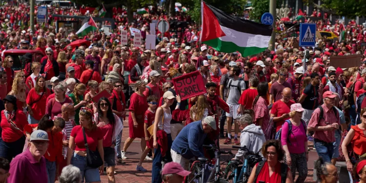 Decenas de miles de manifestantes vestidos de rojo marchan exigiendo que su gobierno haga más para detener la campaña de Israel en Gaza contra Hamás, durante una manifestación en La Haya, Países Bajos, el 15 de junio de 2025. (Foto AP/Peter Dejong)