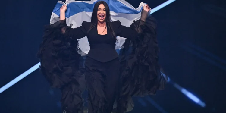 Yuval Raphael, representante de Israel con la canción "New Day Will Rise", desfila con la bandera israelí durante el ensayo general para la final del Festival de la Canción de Eurovisión 2025 en el estadio St. Jakobshalle de Basilea el 16 de mayo de 2025. (Fabrice COFFRINI / AFP)