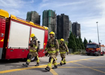 Los bomberos pasan junto a la escena del incendio en Wang Fuk Court, una urbanización del distrito de Tai Po, en los Nuevos Territorios de Hong Kong, el 28 de noviembre de 2025. (Foto AP/Chan Long Hei)