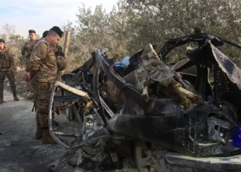Un soldado del ejército libanés inspecciona los restos de un coche que fue blanco de un ataque aéreo israelí cerca de la aldea de Mazraat al Qnaitra, en el sur del Líbano, el 22 de diciembre de 2025. (Mahmoud ZAYYAT / AFP)