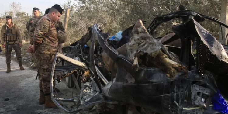 Un soldado del ejército libanés inspecciona los restos de un coche que fue blanco de un ataque aéreo israelí cerca de la aldea de Mazraat al Qnaitra, en el sur del Líbano, el 22 de diciembre de 2025. (Mahmoud ZAYYAT / AFP)