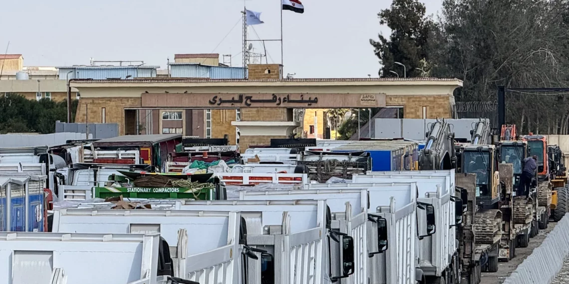 Camiones y maquinaria pesada egipcios se alinean en el lado egipcio del paso fronterizo de Rafah con la Franja de Gaza el 26 de octubre de 2025. (AFP)