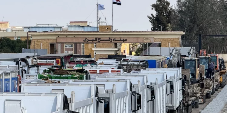 Camiones y maquinaria pesada egipcios se alinean en el lado egipcio del paso fronterizo de Rafah con la Franja de Gaza el 26 de octubre de 2025. (AFP)