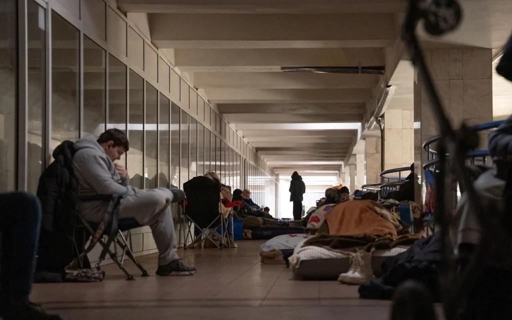La gente se refugia en una estación de metro durante los ataques aéreos rusos en Kiev el 27 de diciembre de 2025. (Serhii Okunev / AFP)