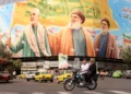 Iraníes viajan en motocicleta frente a una valla publicitaria que representa a los líderes libaneses asesinados de Hezbolá, Hassan Nasrallah (centro) y su sucesor, Hashem Safieddine (derecha), así como al difunto general iraní Qasem Soleimani, en Teherán el 28 de septiembre de 2025. (ATTA KENARE / AFP)