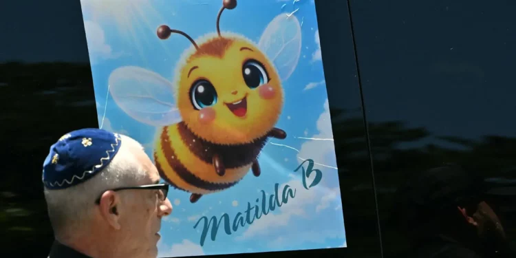 Una pegatina de una abeja que hace referencia a Matilda, de 10 años, asesinada en el atentado terrorista de Bondi Beach, se exhibe en un vehículo mientras una doliente pasa tras su funeral en Sídney el 18 de diciembre de 2025. (Saeed Khan/AFP)