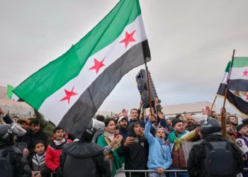 Sirios se alinean en las calles a la espera de un desfile del nuevo ejército sirio que conmemora el primer aniversario del derrocamiento del régimen de Bashar al-Assad en Damasco, Siria, el 8 de diciembre de 2025. (Foto AP/Hussein Malla)