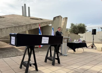 El enviado de rehenes, Gal Hirsch, habla en la ceremonia en honor del ex rehén asesinado Sudthisak Rinthalak antes de que su cuerpo sea trasladado a Tailandia el 9 de diciembre de 2025. (Jessica Steinberg/Times of Israel)