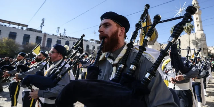Miembros del movimiento scout marchan durante las celebraciones de Nochebuena en la Plaza del Pesebre, frente a la Iglesia de la Natividad en Belén, Cisjordania, el 24 de diciembre de 2025. (Foto: HAZEM BADER / AFP)