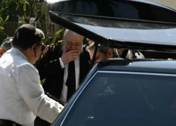 Un familiar del rabino Eli Schlanger, asesinado en el ataque terrorista de Bondi Beach contra un evento de Janucá, reacciona al ver llegar el ataúd para el funeral en la sinagoga Jabad de Bondi en Sídney el 17 de diciembre de 2025. (Saeed Khan/AFP)