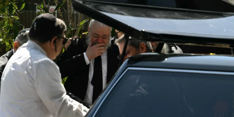 Un familiar del rabino Eli Schlanger, asesinado en el ataque terrorista de Bondi Beach contra un evento de Janucá, reacciona al ver llegar el ataúd para el funeral en la sinagoga Jabad de Bondi en Sídney el 17 de diciembre de 2025. (Saeed Khan/AFP)