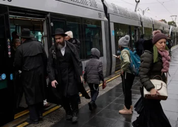 Los pasajeros bajan de un tren ligero durante una mañana lluviosa en medio de la tormenta Byron en Jerusalén, el 10 de diciembre de 2025. (Foto AP/Leo Correa)