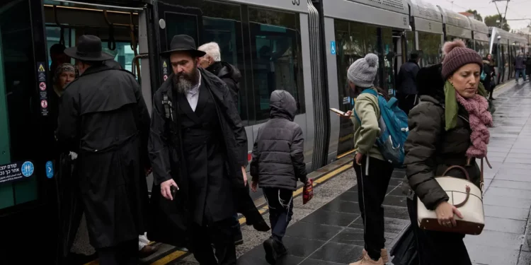 Los pasajeros bajan de un tren ligero durante una mañana lluviosa en medio de la tormenta Byron en Jerusalén, el 10 de diciembre de 2025. (Foto AP/Leo Correa)