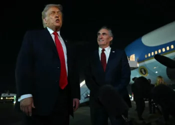 El presidente de Estados Unidos, Donald Trump, habla con periodistas mientras el secretario del Interior, Doug Burgum (derecha), observa, antes de abordar el Air Force One en el Aeropuerto Internacional de Palm Beach, en West Palm Beach, Florida, el 19 de enero de 2026 (ANDREW CABALLERO-REYNOLDS / AFP)
