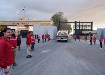 Miembros de la Media Luna Roja Egipcia supervisan un camión que transporta ayuda humanitaria al entrar por el paso fronterizo de Rafah entre Egipto y la Franja de Gaza, tras el acuerdo de alto el fuego entre Israel y Hamás, el 12 de octubre de 2025. (AP Photo/Mohamed Arafat)