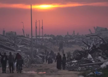 Gazatíes caminan entre las ruinas de edificios destruidos mientras el sol se pone sobre la ciudad de Gaza, el 4 de enero de 2026. (AP/Jehad Alshrafi)