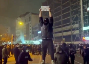 En esta imagen extraída de un vídeo obtenido por la AP fuera de Irán, un manifestante enmascarado sostiene una foto del príncipe heredero de Irán, Reza Pahlavi, durante una protesta en Teherán, Irán, el 9 de enero de 2026. (UGC vía AP)
