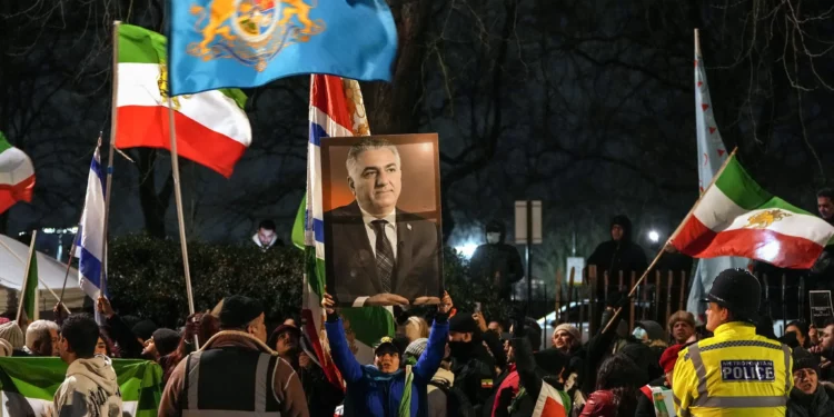 Manifestantes contrarios al régimen iraní sostienen un retrato del último sah de Irán, Reza Pahlavi, mientras participan en una manifestación frente a la embajada iraní en el centro de Londres el 10 de enero de 2026. (CARLOS JASSO / AFP)